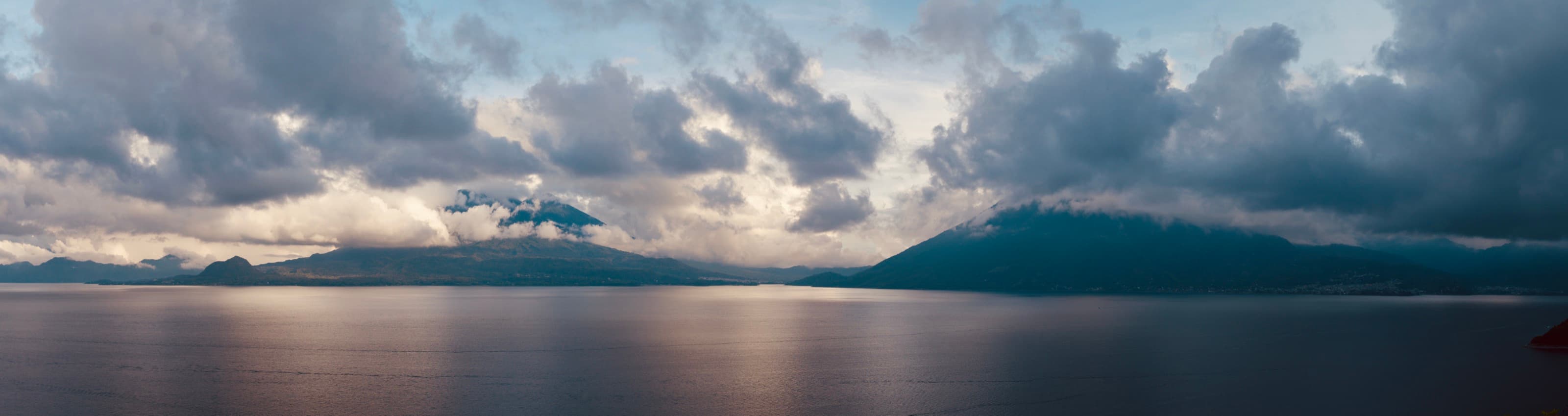 Lake Atitlán and its volcanoes under dramatic clouds